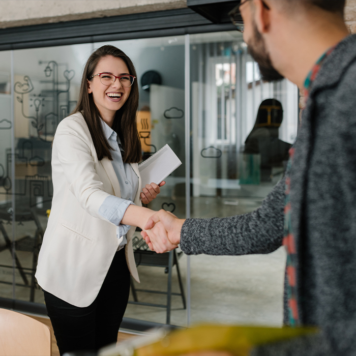 two people smiling and shaking hands