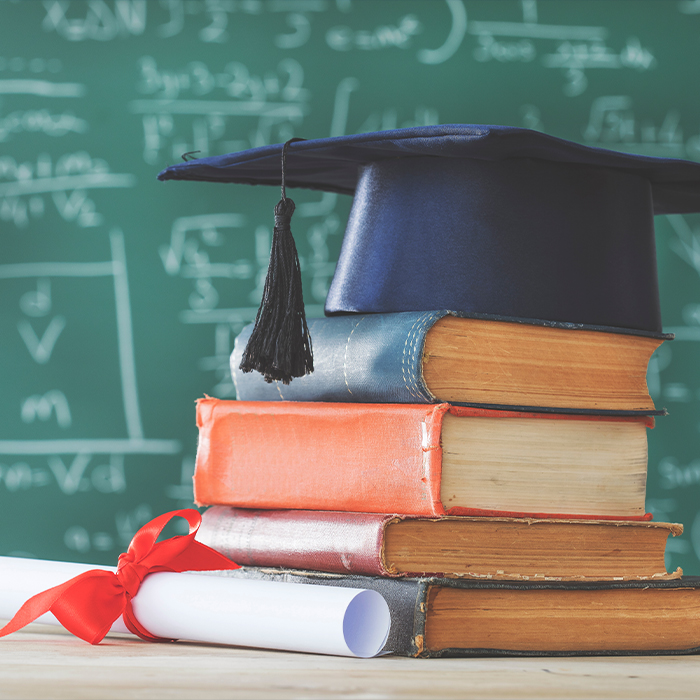 graduation cap on top of stack of books